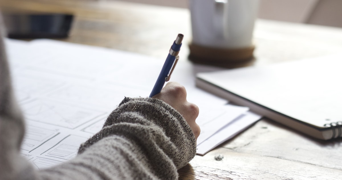 Person researching and writing notes at a desk